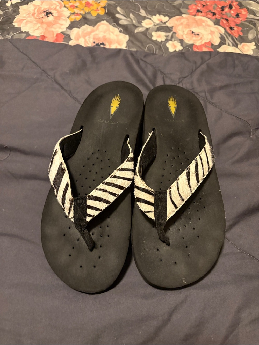 Volatile Black Flip Flop Sandals with White Zebra-Striped Straps